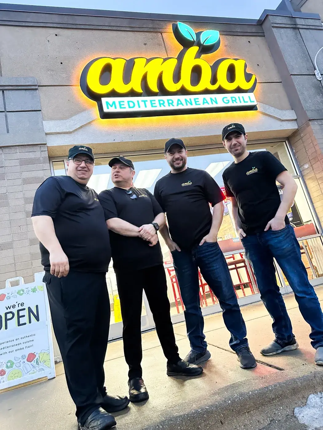 The four brothers standing outside the AMBA Mediterranean Grill storefront